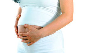 Una donna incinta tiene il suo basso addome