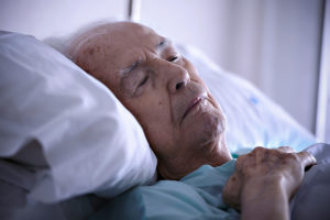 Vecchio nel letto d'ospedale